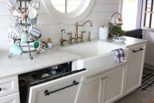 26 a dishwasher hidden in a cabinet to perfectly match the vintage farmhouse design of the kitchen and not to add a modern touch to its chic look