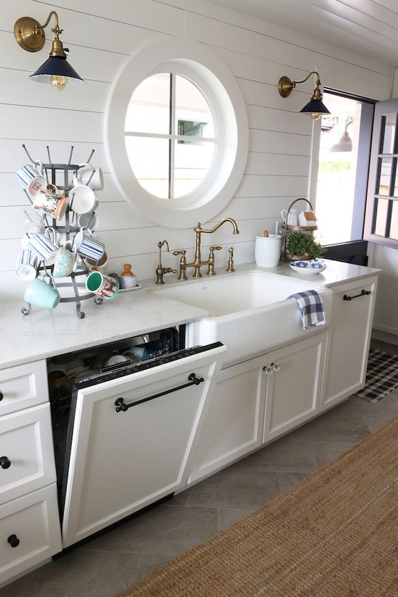 a dishwasher hidden in a cabinet to perfectly match the vintage farmhouse design of the kitchen and not to add a modern touch to its chic look