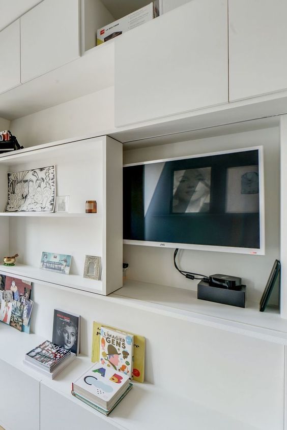 a TV hidden under a shelving unit that can slide and let you watch TV - this is a stylish and cool idea