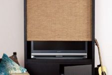29 a TV unit with a storage cabinet and a woven shade that can easily hide your TV is a creative modern idea