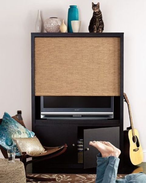 a TV unit with a storage cabinet and a woven shade that can easily hide your TV is a creative modern idea