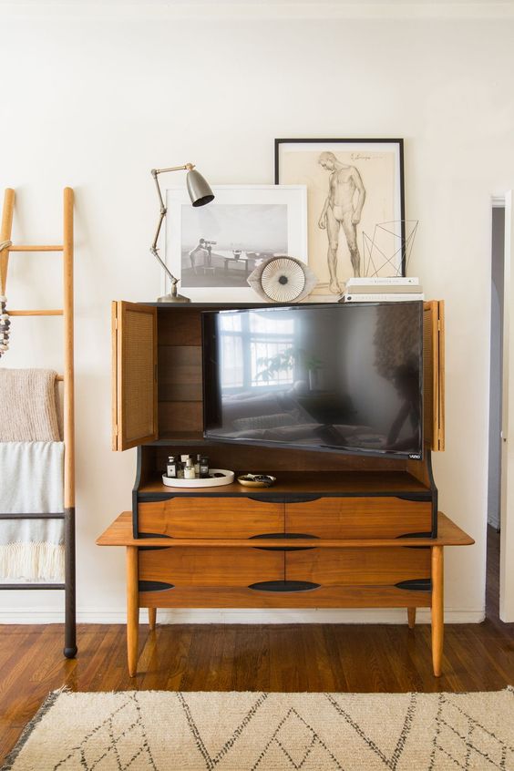 a vintage rich-stained storage cabinet that holds a TV and can hide it anytime with cane bi-fold doors is a lovely idea for a modern room