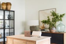 30 a whimsical and eye-catchy home office wiht a black storage unit and a glass buffet, a stained desk and a cowhide rug