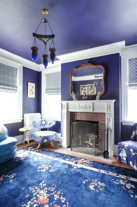 a fabulous very peri vintage living room with a fireplace and a vintage mantel, a catchy pendant amp and blue and purple floral print furniture