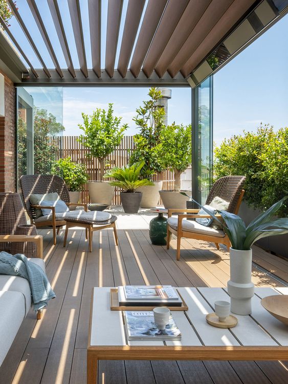 a chic and stylish rooftop terrace with a slight planked roof, potted plants and trees, rattan and woven furniture and a low coffee table
