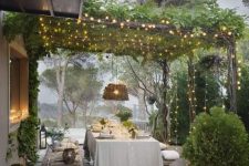 51 a lovely Provence outdoor dining space with elegant dining furniture, white linens, woven pendant lamps, greenery and lots of lights