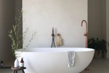 54 a beautiful contemporary spa bathroom with an oval tub, a dark-stained sotol, a jute rug and some greenery