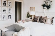 57 an elegant neutral bedroom with a creamy upholstered bed, a grey loveseat, a refined gallery wall, a beaded chandelier and a wreath