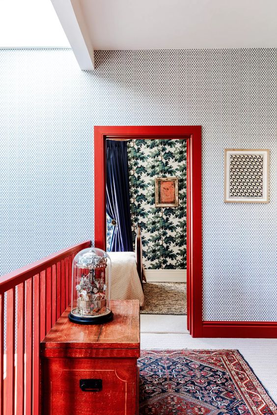 a beautiful and elegant space with printed wallpaper, bold coquelicot woodwork and a console table that spruces up this neutral space