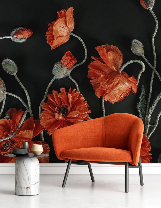 a bold nook with a gorgeous coquelicot flower mural and a matching large chair, a stone side table and chic vases