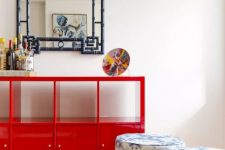 a bold space with a graphic rug, printed stools, a coquelicot credenza and an Asian-inspired mirror on the wall