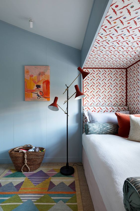 a catchy space with a windowsill daybed, a catchy coquelicot printed wallpaper accent, a coquelicot floor lamp and a printed rug