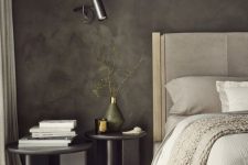a chic contemporary bedroom with grey limewashed walls, a creamy bed and graphite grey nightstands and sconces