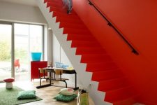 a contemporary space with a coquelicot wall and staircase, colorful pillows and rugs and bright furniture pieces