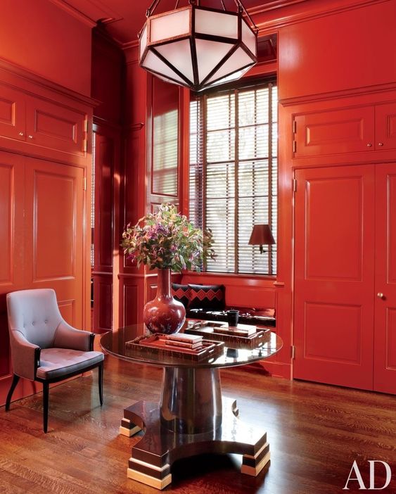 a fantastic coquelicot space with wainscoting, a built-in windowsill bed, a black table, a gorgeous faceted pendant lamp