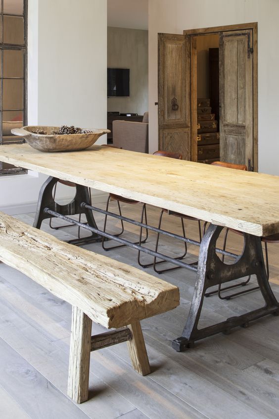a metal and rough wood dining table plus a rough wooden bench are ideal for a wabi-sabi interior like this one