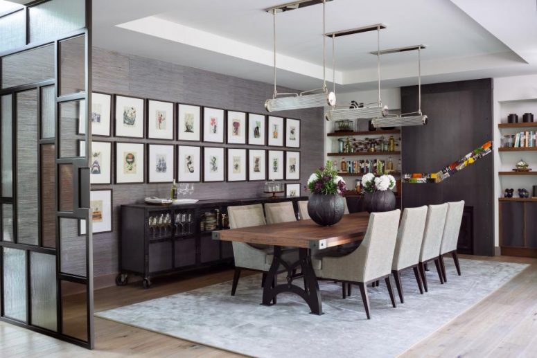 a modern and vintage dining room with a grey grasscloth wallpaper, a gallery wall, shelves and a credenza, a dining table and grey chairs