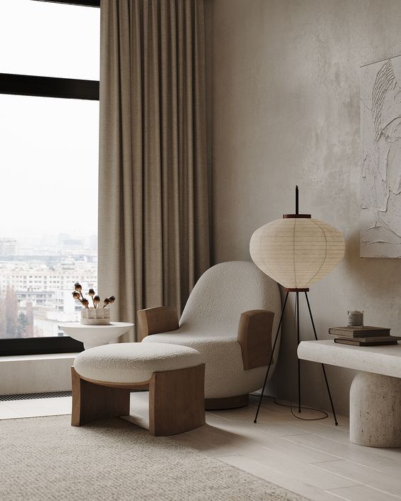 a neutral minimalist space with neutral limewashed walls, a white stone bench, a catchy and soft chair with a footrest