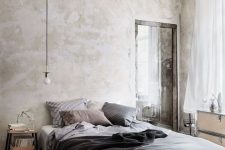 a relaxed bedrom with neutral limewashed walls, a floating bed, light-stained furniture and grey bedding