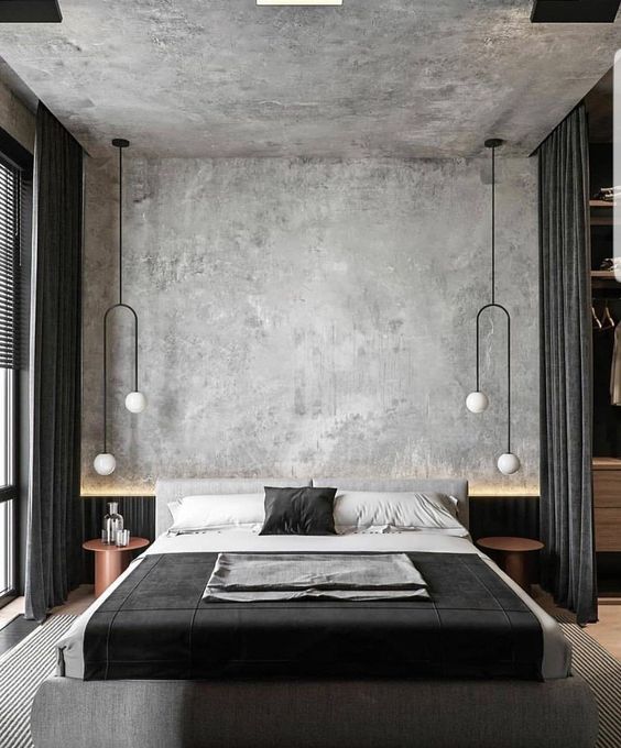a stylish contemporary bedroom with a grey limewashed wall and a ceiling, a grey upholstered bed with black and white bedding, copper nightstands and unique pendant lamps