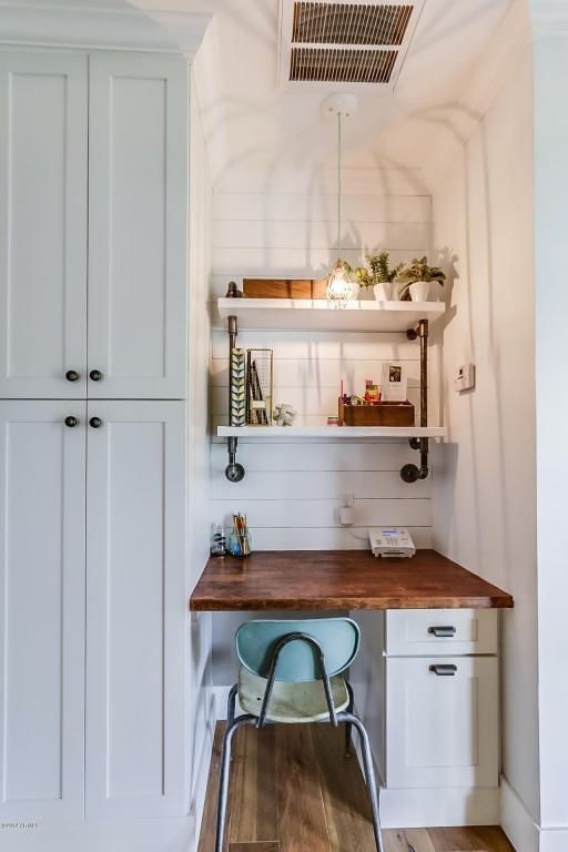 a farmhouse awkward nook done with white shiplap, a built-in desk, built-in shelves, a pendant lamp and potted greenery for working