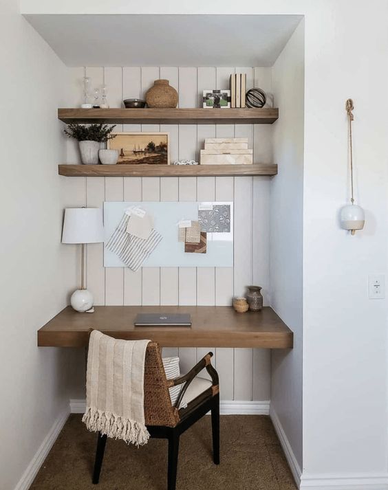 an awkward nook turned into a small working space, with built-in shelves and a desk, a woven chair and various decor is cool