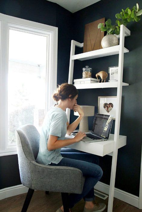 a small awkward nook turned into a practical working space with a white shelving and desk unit, some greenery and a comfy chair