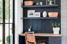 36 a small navy nook with shiplap, a built-in desk, open shelves, a woven chair and potted plants and leather baskets
