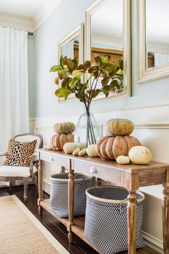 simple and natural Thanksgiving styling with real pumpkins, a foliage arrangement in a clear vase and chevron baskets
