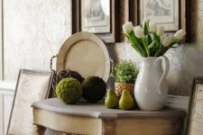 white tulips in a jug, moss balls, potted greenery and some faux pears for a rustic look