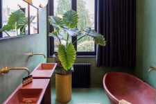 32 a green maximalist bathroom with red free-standing sinks, a red oval bathtub, a neutral rug, potted plants and a mirror, black curtains