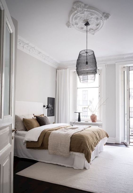 a Scandinavian bedroom with a chic and cool ceiling medallion, a black pendant lamp with mesh and a bulb for a contrast