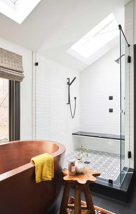a black and white bathroom with skylights, a copper oval bathtub and a wooden sotol, much natural light coming through windows and skylights