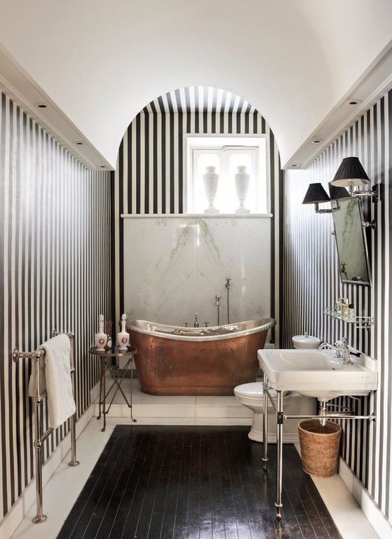 a chic vintage-inspired monochromatic bathroom with a copper bathtub that adds warmth and color to the space