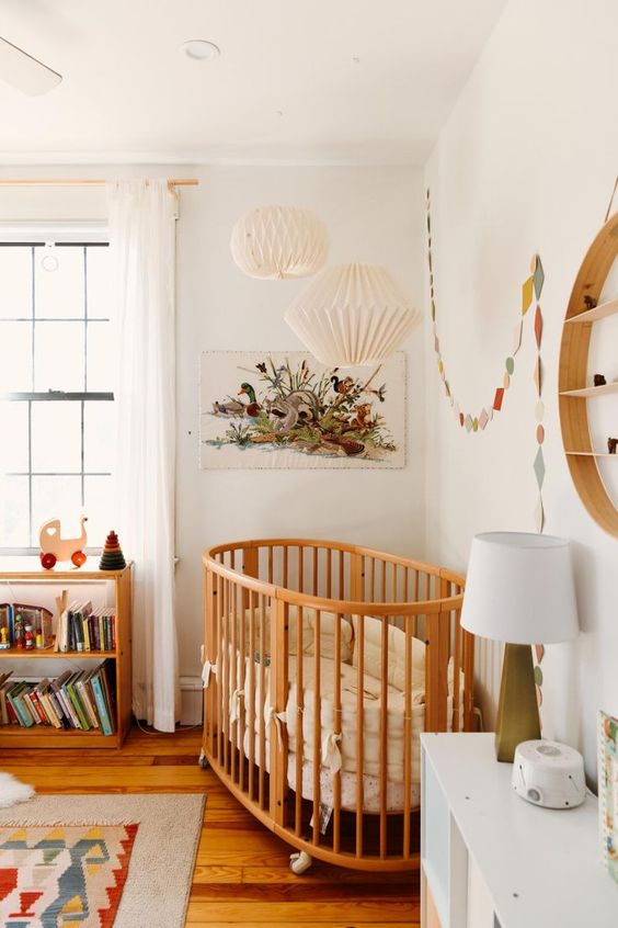 a cute mid-century modern nursery with a stained shelf, a stained crib with neutral bedding, a bold printed rug, colorful decor