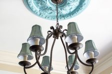 a light blue ceiling medallion and a vintage metal chandelier with green lampshades for adding color and a chic vintage feel to the space