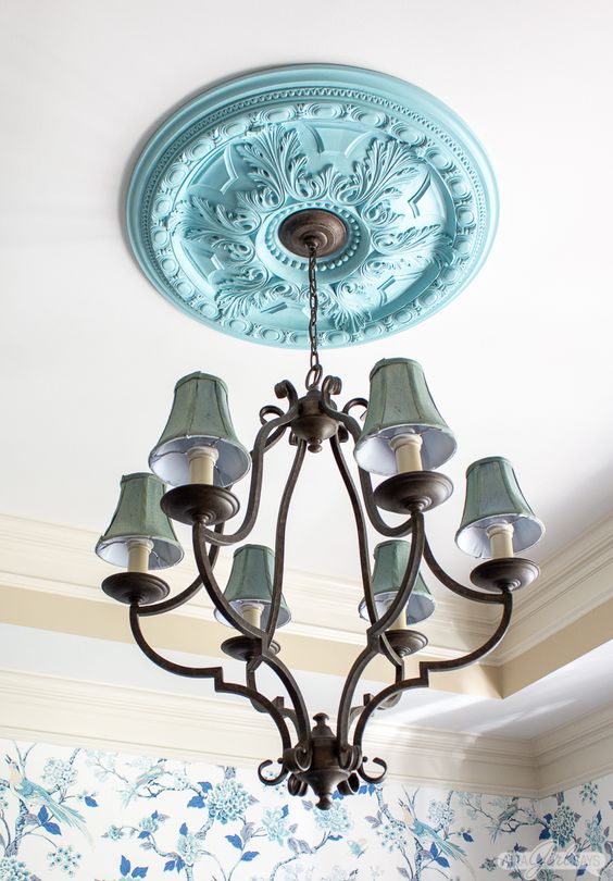 a light blue ceiling medallion and a vintage metal chandelier with green lampshades for adding color and a chic vintage feel to the space