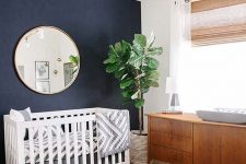 a lovely nursery with a navy accent wall