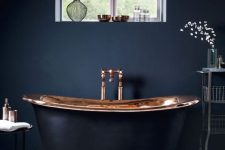 a modern luxurious bathroom with black walls, a mosaic tile floor, a copper and black tub and elegant furniture