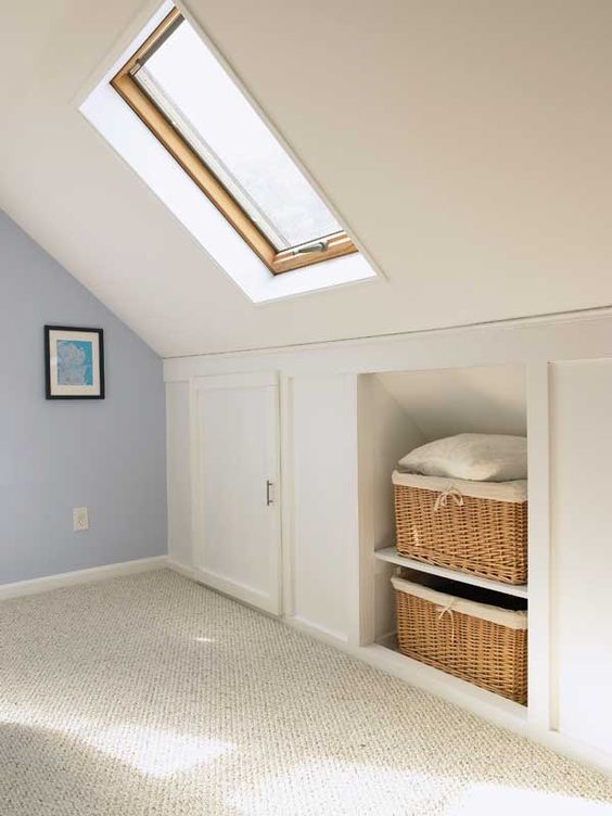a pretty neutral attic room with built-in storage - baskets for storage and storage compartments with doors is amazing