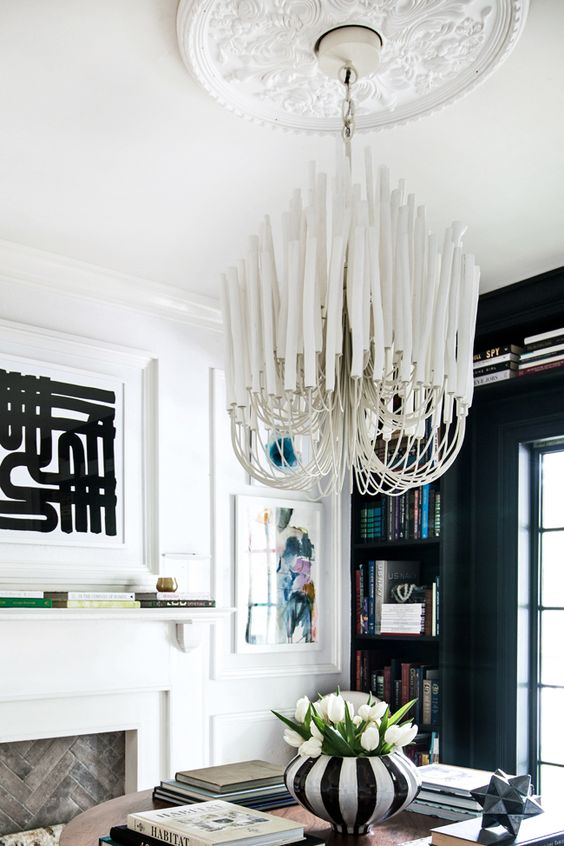 a refined white ceiling medallion paired with an absolutely jaw-dropping modern chandelier with long white bulbs