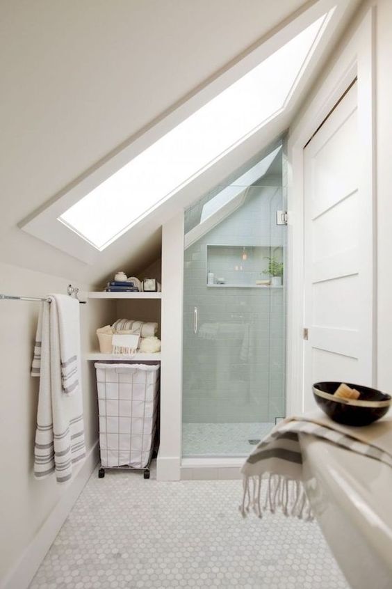 a small attic bathroom with skylights and a shower space, with built-in attic storage and a sink is a smart use of space