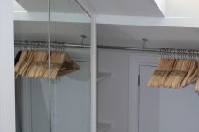a small attic closet with a mirror storage compartment and an additional clothes holder is a lovely idea