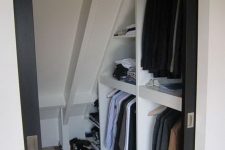 a small attic walk-in closet with open storage compartments and shelves is a cool solution that features a lot of storage space