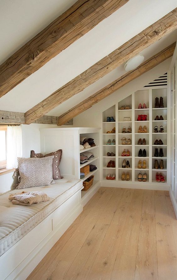 a small yet cozy attic space with a windowsill daybed and built-in shoe shelves and clothes shelves is a very cool idea