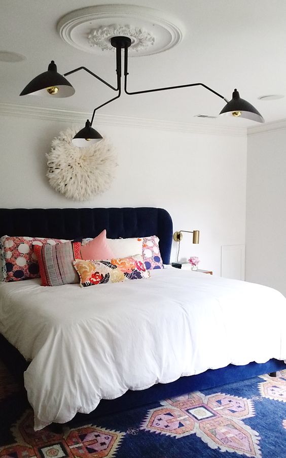 a stylish and cool ceiling medalltion paired with a black modern lamp with three parts to create a bold contrast and keep up the style of the space