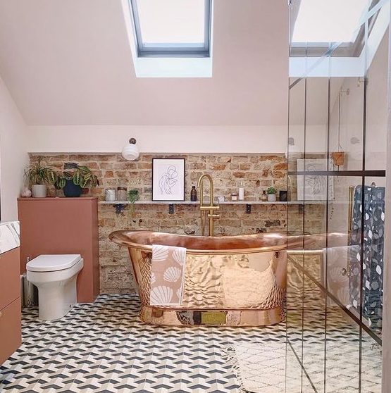 a stylish eclectic bathroom with a mosaic tile floor, a brick wall, skylights and a copper bathtub that is a centerpiece here