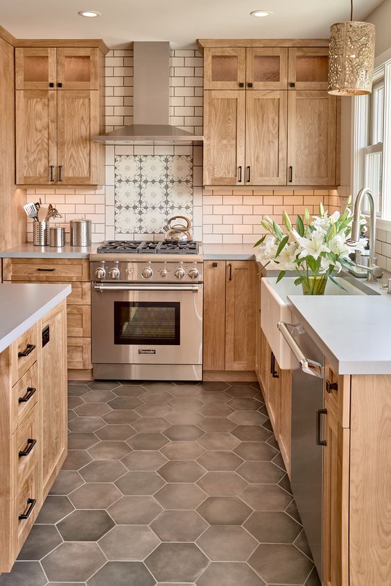 a welcoming stained kitchen with shaker style cabinets white stone countertops and a white subway tile backsplash plus taupe hex tiles