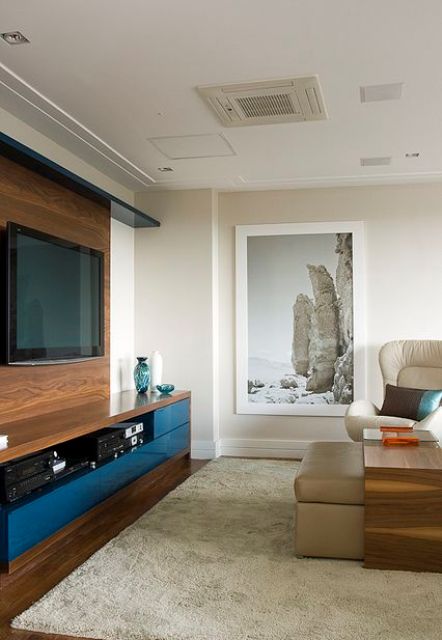 a modern living room done in neutrals, with a wall-mounted TV, a faux timber wall that hides the wires and matches the look of the media console