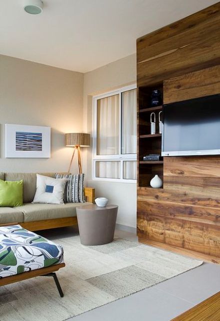 a stylish mid-century modern living room done in neutrals and brights, with a stained wooden storage unit and a TV on it, with wires hidden inside the piece